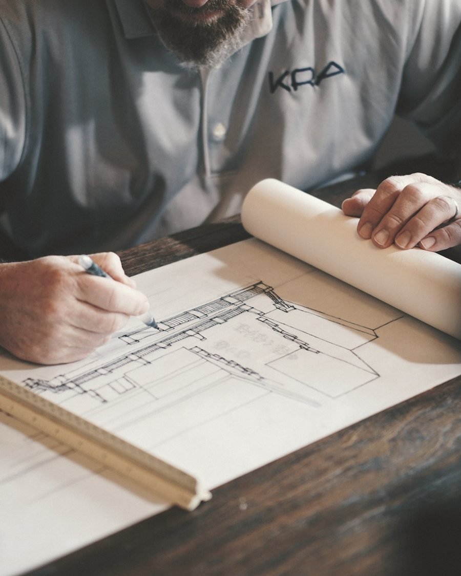 Elin Dwell's hands drawing a full-scale table at the bench